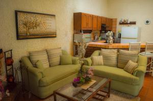 a living room with two couches and a kitchen at Private Villa in Guadalajara with heated Swimming Pool in San Agustín