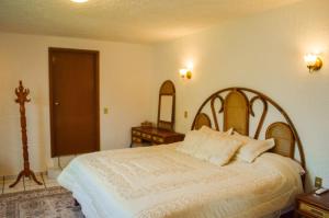 a bedroom with a large bed with white sheets and pillows at Private Villa in Guadalajara with heated Swimming Pool in San Agustín +23 photos