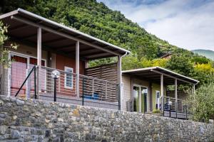 a house with a stone wall in front of it at Camping Eurovil in Predore