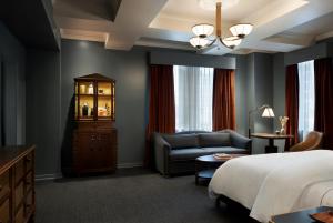 a hotel room with a bed and a chair at The Driskill in Austin +125 photos