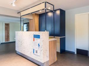 a exhibit in a room with blue cabinets at Ibis Budget Villefranche in Limas