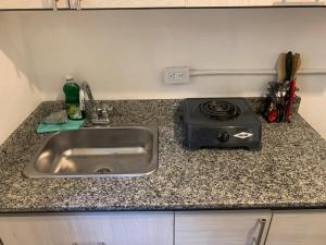a kitchen counter with a sink and a stove at Hotel Casa Lucca in Medellín +127 photos