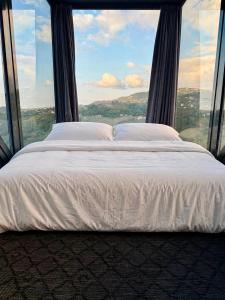 a bed in a room with a large window at Lazord Glass Bungalow Trabzon in Geçit