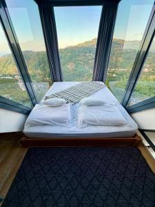 a bed in a room with a large window at Lazord Glass Bungalow Trabzon in Geçit +67 photos