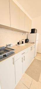 a white kitchen with white cabinets and a sink at טבריה 622 in Tiberias