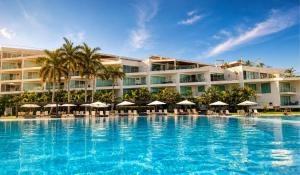 a resort with a large swimming pool with chairs and umbrellas at Aria Ocean in Nuevo Vallarta
