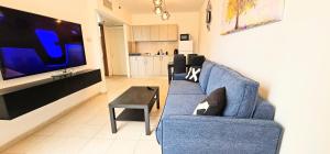 a living room with a blue couch and a tv at טבריה 622 in Tiberias