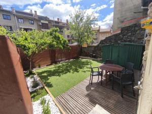 a patio with a table and chairs and a small yard at Apartament l'Adou in Bagá +1 photo