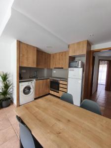 a kitchen with a table with chairs and a washer at Apartament l'Adou in Bagá