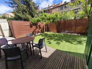 a patio with a table and chairs and a lawn at Apartament l'Adou in Bagá