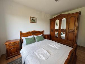 a bedroom with a large bed with a wooden headboard at Casa Alexana in Gura Humorului