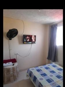 a bedroom with a bed and a tv on the wall at Alojamiento Central Ibagué in Ibagué