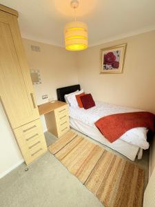 a small bedroom with a bed and a desk at caddys lodge in Tydd Saint Giles +26 photos