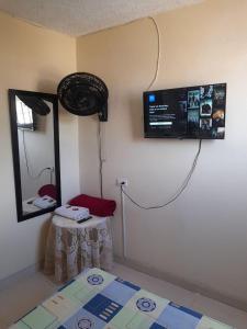 a room with a television on the wall and a table at Alojamiento Central Ibagué in Ibagué