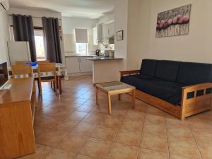 a living room with a blue couch and a kitchen at Castelos da Rocha in Portimão