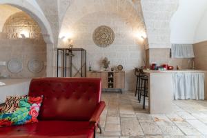 a living room with a red couch and a kitchen at Gente di Mare Luxury Home in Fasano