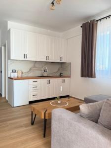a kitchen with white cabinets and a table in a living room at Filikuri Boutique Hotel in Himare