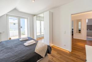 ein Schlafzimmer mit einem Bett, auf dem zwei Handtücher liegen in der Unterkunft 2 Schlafzimmer, Offene Küche, Balkon und Terrasse - moderne 90qm in ruhiger, zentraler Lage - nur 500m bis zum Strand in Warnemünde