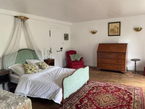 a bedroom with a bed and a dresser at Château de Saint-Pois in Saint-Pois