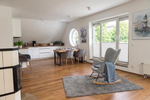 eine Küche und ein Wohnzimmer mit Tisch und Stühlen in der Unterkunft 2 Schlafzimmer, Offene Küche, Balkon und Terrasse - moderne 90qm in ruhiger, zentraler Lage - nur 500m bis zum Strand in Warnemünde
