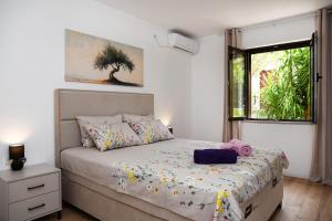 a bedroom with a bed and a window at Studio Apartments Summer Time in Kamenari