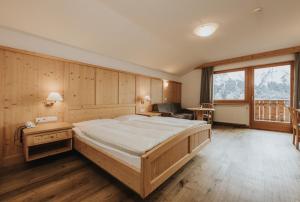 a bedroom with a large bed in a room at Hotel Plunger in Castelrotto +36 photos