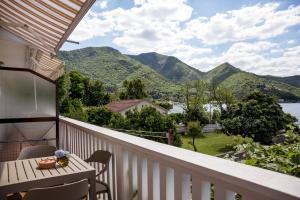 a balcony with a table and chairs and mountains at Studio Apartments Summer Time in Kamenari