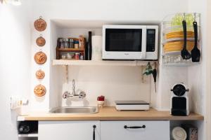 a kitchen counter with a sink and a microwave at Dolce Barzio - appartamento in centro in Barzio