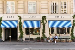 two women sitting at tables in front of a hotel at Coco Hotel in Copenhagen
