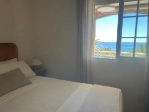 a bedroom with a bed with a view of the ocean at Apartamento LH Beach frente al mar in La Herradura