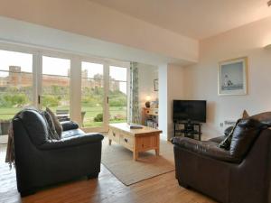 a living room with two leather couches and a television at Northrawe in Bamburgh