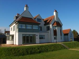 a large white house with a red roof at Northrawe in Bamburgh