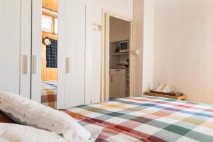 a small bedroom with a bed and a kitchen at Dolce Barzio - appartamento in centro in Barzio