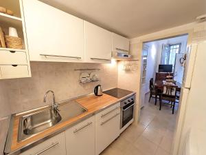 a kitchen with white cabinets and a sink at Libeccio House in Avola +5 photos