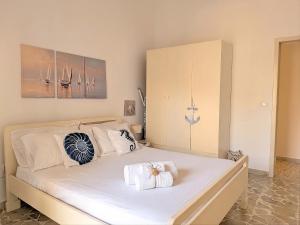 a bedroom with a white bed with towels on it at Libeccio House in Avola