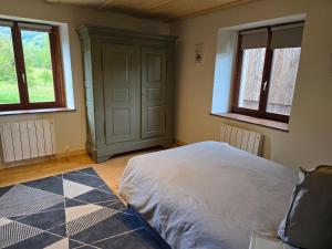 a bedroom with a bed and two windows at Echappée Verte in Breitenbach-Haut-Rhin
