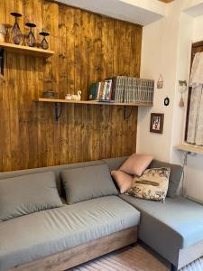 a couch in a room with a wooden wall at Dolce Barzio - appartamento in centro in Barzio +2 photos
