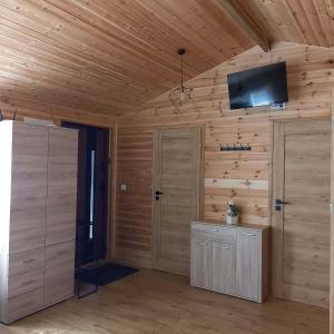 a room with wooden walls and a tv on the wall at Ostoja Semlińska in Semlin +18 photos