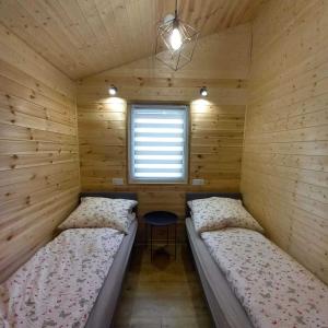 a room with two beds in a wooden cabin at Ostoja Semlińska in Semlin