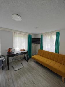 a living room with a couch and a desk at Hotel Freihof in Glarus