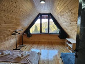 a room with a bed and a large window at Brvnara Tarin osmeh - u srcu Nacionalnog parka Tara in Sekulić 
