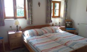 a bedroom with a large bed with two windows at Ferienhaus Goldegg 1 in Artstetten