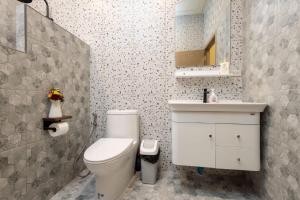 a bathroom with a white toilet and a sink at Villa Casa Blanca in Wok Tum