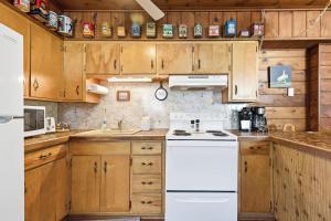 a kitchen with wooden cabinets and a white stove top oven at Chalet #57 in Stevensville