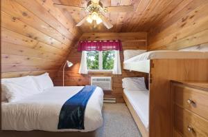 a bedroom with two beds in a wooden cabin at Chalet #57 in Stevensville