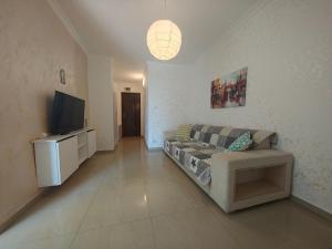 a living room with a couch and a flat screen tv at Dika Sofia Residence in Mangalia