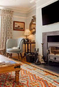 a living room with a chair and a fireplace at Ty'n Porth - By Rowes Retreats in Falmouth