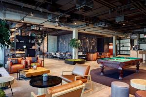 a room with a pool table and couches at Me and All Hotel Kiel, by Hyatt in Kiel