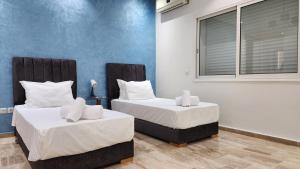 two twin beds in a room with a window at Family fun farm - Évasion Nature - piscine et ferme in Berrechid +71 photos