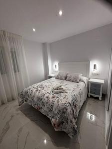 a white bedroom with a bed with a floral bedspread at Mi Capricho in Mijas Costa +115 photos